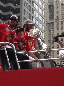 Duncan Keith with his son and Brent Seabrook holding the Stanley Cup.